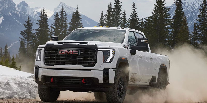 White 2026 GMC Sierra 2500 HD standing on a scenic mountain overlook.