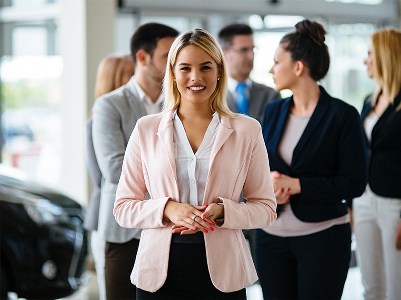 A smilling women is stands front of team